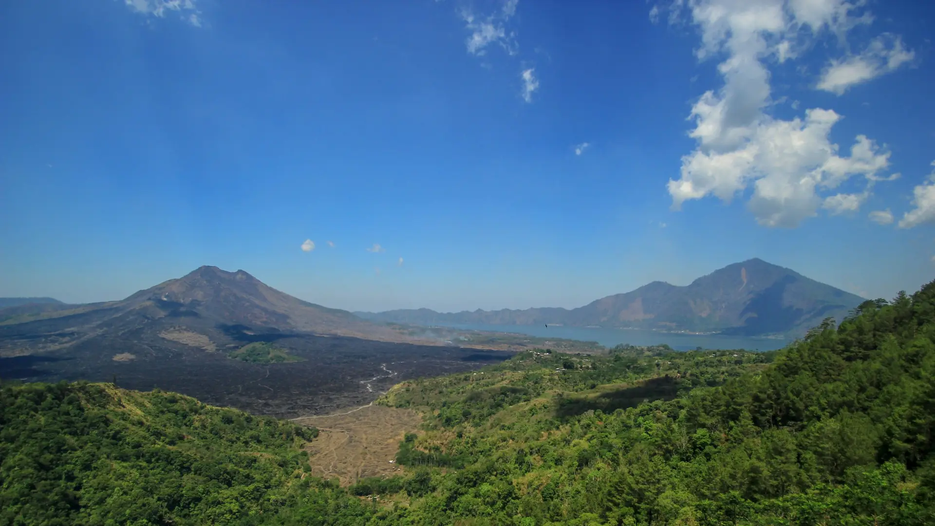Aerial view of Mount Batur above a green valley